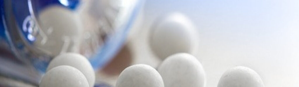 Extreme macro of homeopathic medications - small white balls and the container